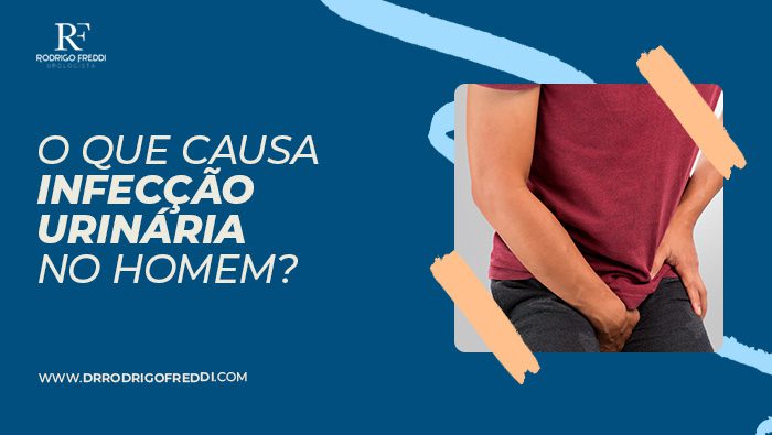 Homem vestindo camiseta vermelha e calça escura segurando a área genital, aparentando desconforto, sugerindo problemas urinários ou dor na região pélvica.